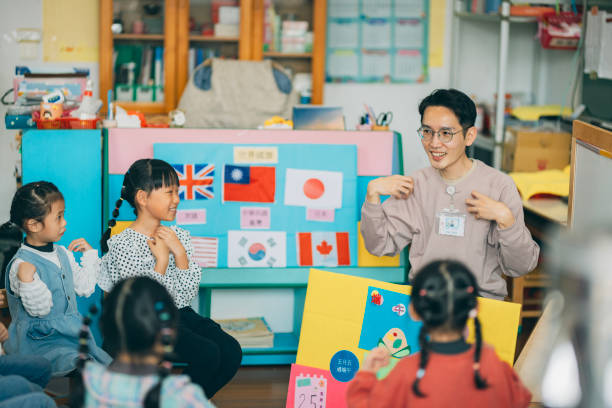 An Asian male teacher and his students vividly explain the origin of the traditional festival of Dragon Boat Festival and introduce related rich cultural knowledge through finger rhymes and children's songs. They explain that Dragon Boat Festival is celebrated on the fifth day of the fifth month of the lunar calendar, during which people participate in traditional customs such as dragon boat races, hanging fragrant sachets, and enjoying delicious zongzi.